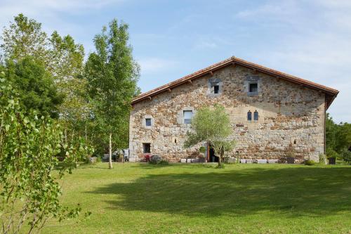an old stone building in a field with trees at Heredad de Unanue in Donostia-San Sebastián
