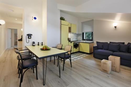 sala de estar y cocina con mesa y sofá en Appart'hôtel Bellamy Chamonix en Chamonix-Mont-Blanc