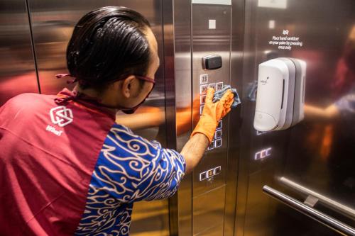 a man is putting something in a vending machine at Crowne Plaza Bandung by IHG in Bandung