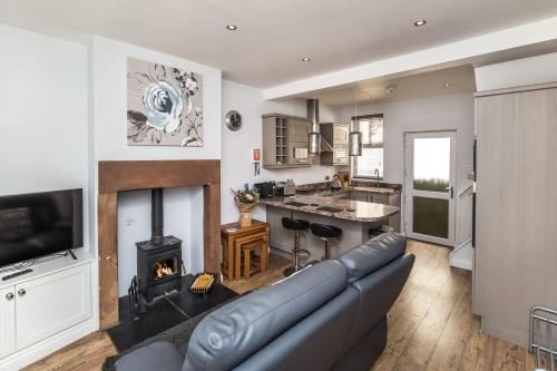 a living room with a couch and a fireplace at Isabel Cottage in Keswick