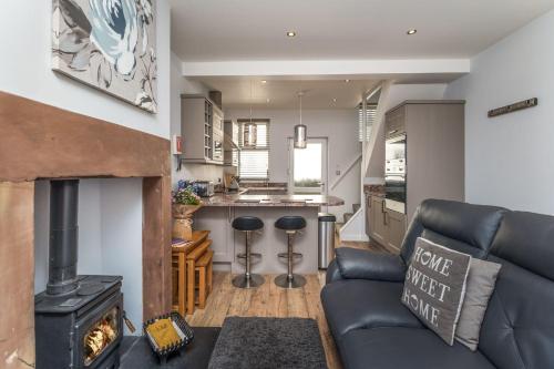 a living room with a couch and a fireplace at Isabel Cottage in Keswick