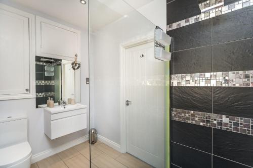 uma casa de banho com um chuveiro, um WC e um lavatório. em Isabel Cottage em Keswick