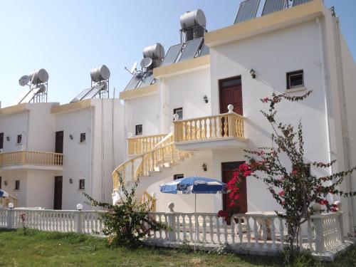 a white building with a staircase and a balcony at Paradise in Kérynia