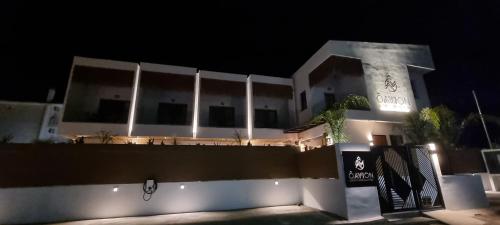 a white building with a fence in front of it at night at Olvion Luxury Living in Kallithea Halkidikis