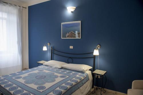 ein blaues Schlafzimmer mit einem Bett mit blauer Wand in der Unterkunft Casa Vacanze Mare Blue in Vietri
