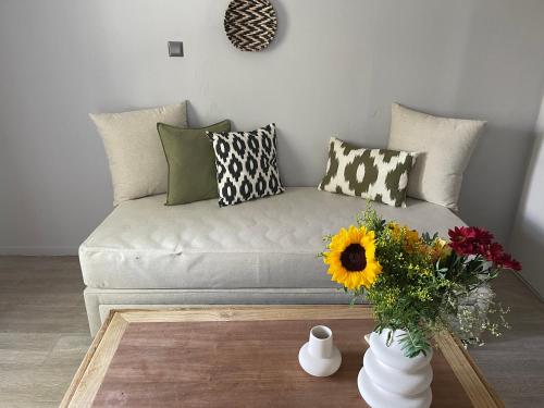 a living room with a couch with a vase of flowers at Rania Apartments Sea View in Mýkonos City