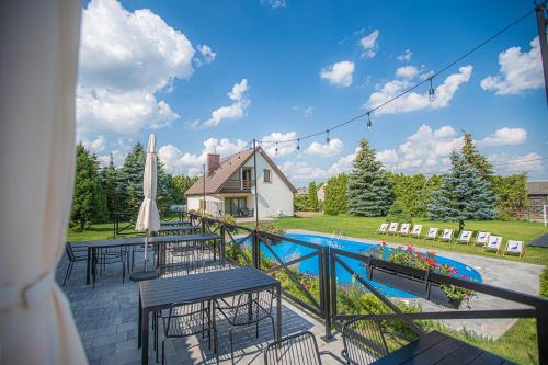 a patio with tables and a pool and a house at Gościniec Pajewo in Pajewo