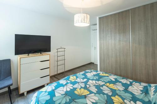 une chambre avec un lit et une télévision sur une commode dans l'établissement ocagna, à Sausset-les-Pins