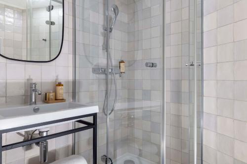 a bathroom with a shower and a sink at Hôtel Hélios Opéra in Paris
