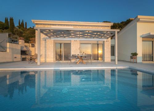 a swimming pool in front of a villa at Owl Villas in Drymon