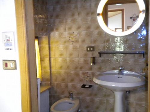 bagno con lavandino e specchio di House Casa Defrancesco a Moena