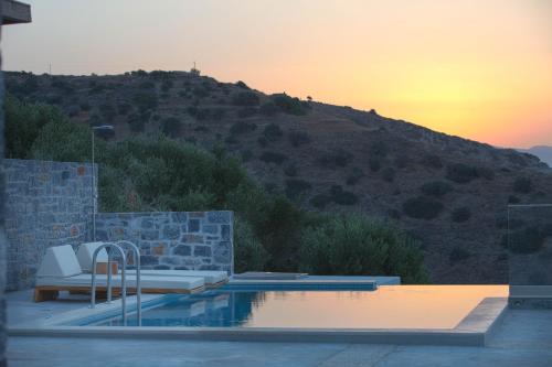 a swimming pool with a view of a hill at Acantha Villas in Mochlos