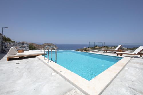 a swimming pool with a view of the ocean at Acantha Villas in Mochlos