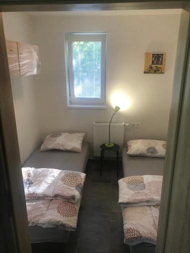Cette chambre comprend 3 lits et une fenêtre. dans l'établissement chata Modrá, à Vinné