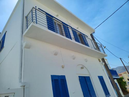 ein weißes Gebäude mit blauen Fensterläden darauf in der Unterkunft Fotini & Dimitrios in Fri