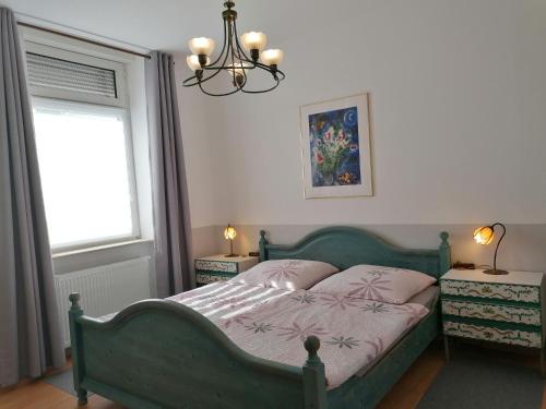 Un dormitorio con una cama verde y una lámpara de araña. en Kaiserliches Postamt Cobern en Kobern-Gondorf