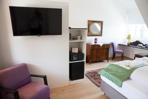 a bedroom with a bed and a tv on a wall at Gasthof zum Goldenen Anker in Hainburg an der Donau