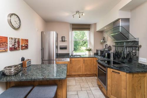 a kitchen with wooden cabinets and a stainless steel refrigerator at Lords Seat in Keswick