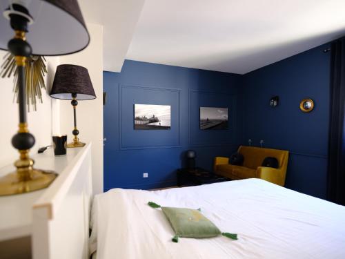 een slaapkamer met blauwe muren en een bed en een stoel bij Le Floreal, great quiet appt in very town center in Tours
