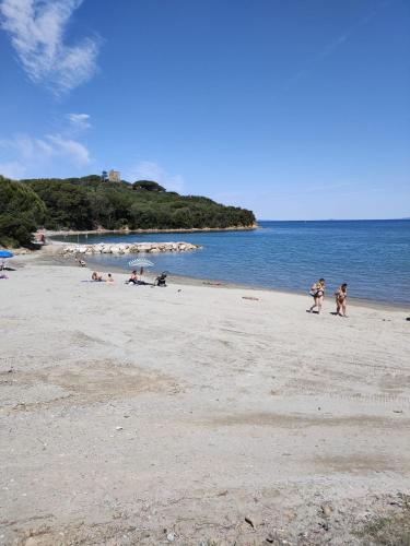 a group of people walking on a beach at Casa sul Mare - Punta Ala in Punta Ala