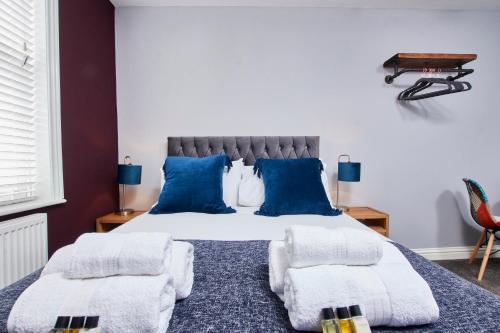 - une chambre avec un grand lit et des oreillers bleus dans l'établissement Delven House, Apartment 5, à Castle Donington