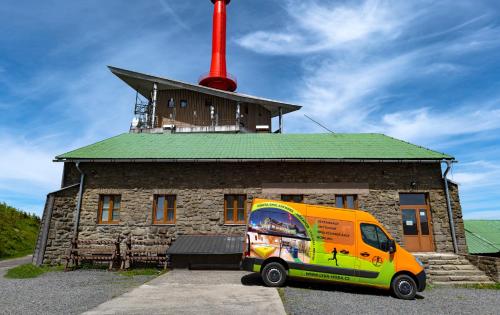 a yellow van parked in front of a building at Chata Emil Zatopek - Maraton - Lysa Hora in Krásná
