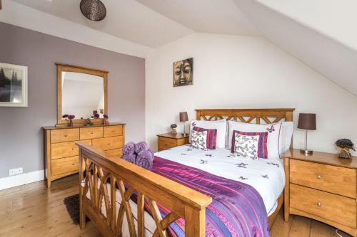 una camera con letto in legno e specchio di Stanger Cottage a Keswick