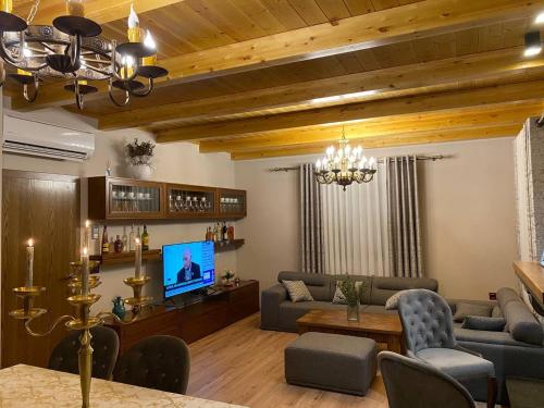 ein Wohnzimmer mit einem Sofa und einem TV in der Unterkunft Iballe Guesthouse in Pukë