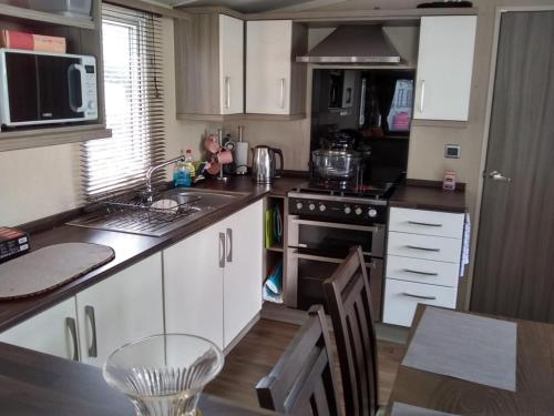 a kitchen with a sink and a stove top oven at 57 Tay in Forfar