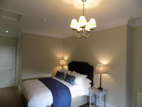 a bedroom with a bed and a chandelier at Flynns of Termonfeckin Boutique Hotel in Termonfeckin