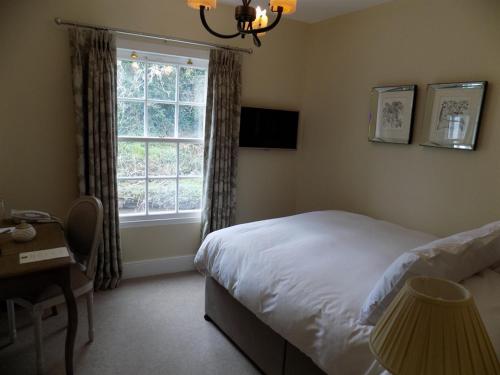 a bedroom with a bed and a window and a desk at Flynns of Termonfeckin Boutique Hotel in Termonfeckin