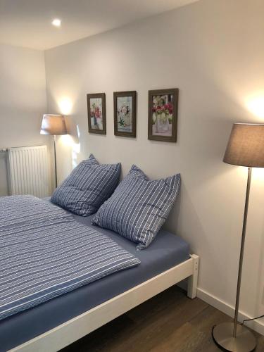 a bedroom with a bed with blue sheets and two pillows at Ferienchalet-Floesswehrtal in Bad Lauterberg
