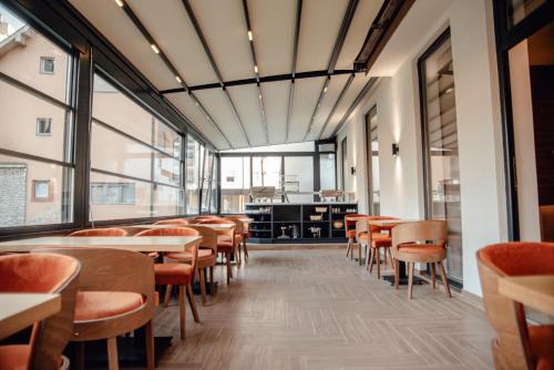 MK Premier في نوفي بازار: غرفة طعام مع طاولات وكراسي ونوافذ