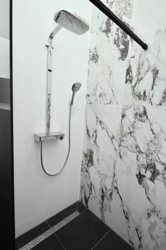 a shower with a shower head in a bathroom at Bed, Bites & Business Hotel Rotterdam in Rotterdam
