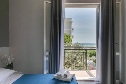 1 dormitorio con cama y ventana con vistas en Hotel Quisisana, en Rímini