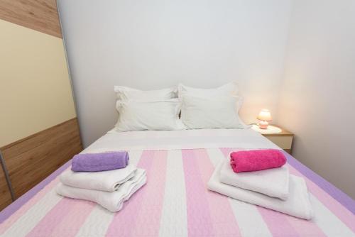 a bedroom with a bed with towels on it at Apartment Đego near Ploce, riverfront, parking in Rogotin