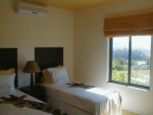Mountain view house 9 Diemersfontein في ويلينغتون: غرفة فندقية بسريرين ونافذة