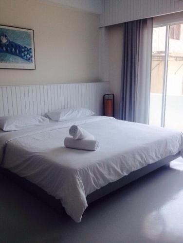 a white bed with a towel on top of it at Cha_Inn @ Cha Am in Cha Am