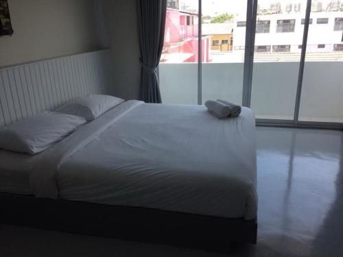 a bed in a bedroom with a large window at Cha_Inn @ Cha Am in Cha Am