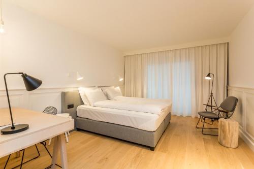 Habitación de hotel con cama, escritorio y escritorio. en De Sjeiven Dorpel, en Maaseik