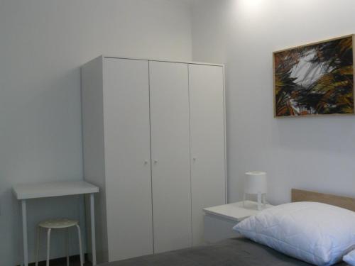 a bedroom with a white cabinet next to a bed at CENTRUM in Włocławek