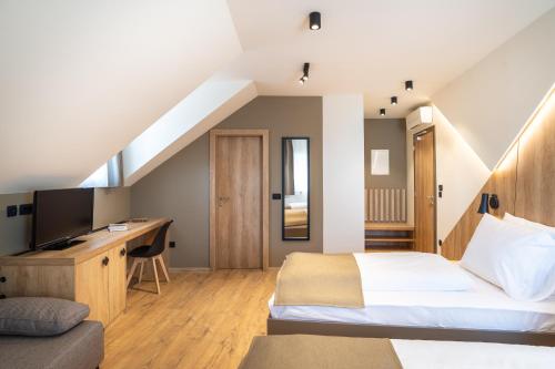 a bedroom with a bed and a desk with a television at Penzion Repanšek in Radomlje