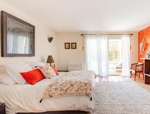 a bedroom with a large white bed with red pillows at La Petite Aiguebonne in Allex