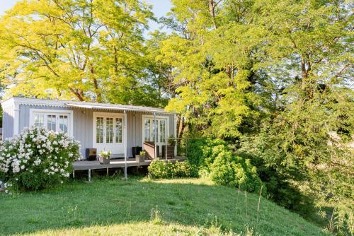 a small white cottage in a yard with trees at La Petite Aiguebonne in Allex