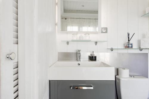 a white bathroom with a sink and a toilet at La Petite Aiguebonne in Allex