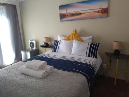 a bedroom with a bed with towels on it at Serenity Cove-Beach Blue Room in Hallack Rock