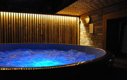 a jacuzzi tub with blue water in a room at WIlla JODŁA JACUZZI&SAUNA in Poronin