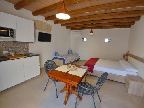 a kitchen and a bedroom with a bed and a table at Cava Rossa in Favignana