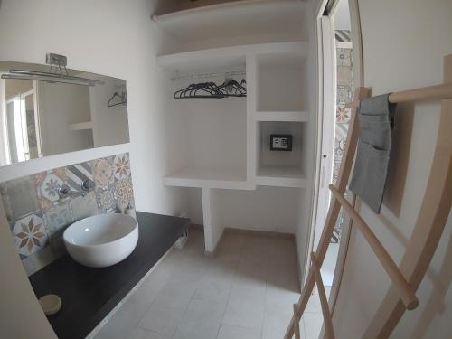 a bathroom with a sink and a toilet in it at Cava Rossa in Favignana