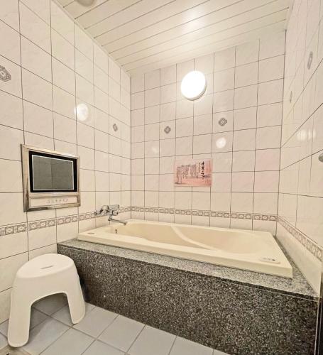 a bathroom with a tub and a toilet and a tv at HOTEL THE i Adult only in Higashi-osaka